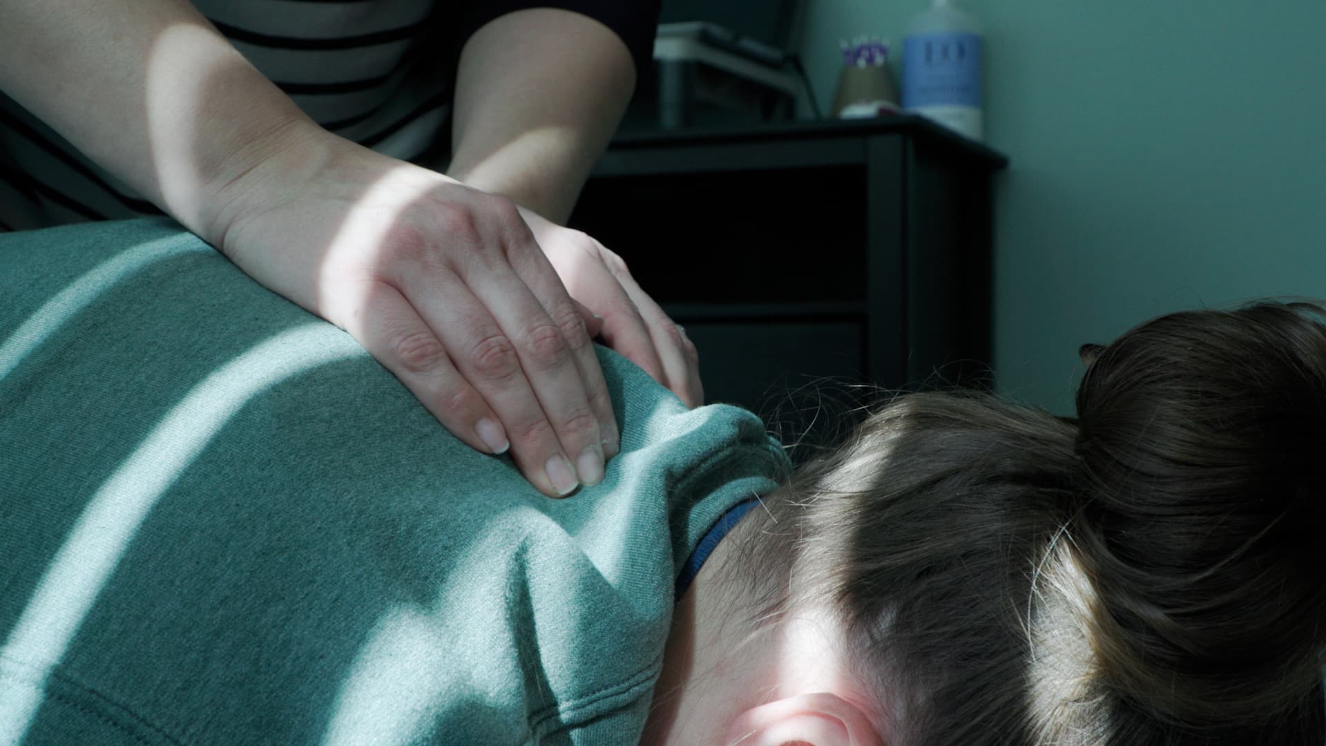 Hands adjusting a patient’s upper back